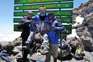 Dr Maroon at the Summit of Mt Kilimanjaro Holding WWE Banner
